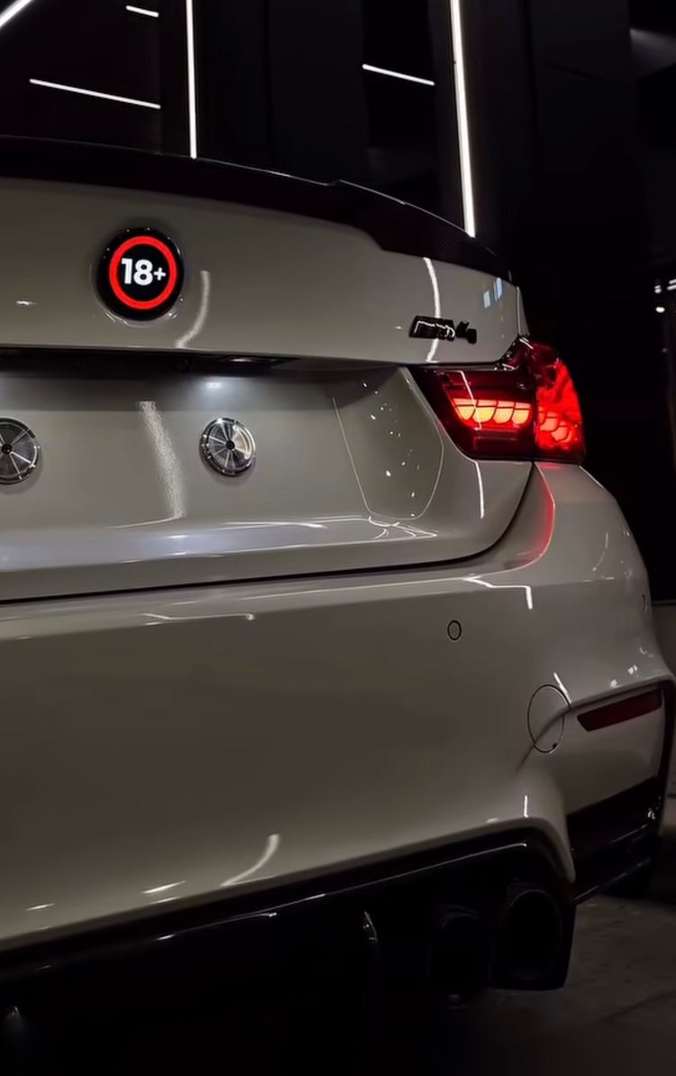 Anku Dot dijital logo ekranı, beyaz BMW bagajında 18+ görseliyle gece